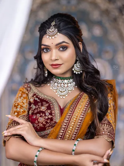 This model showcases a beautiful Kundan and pearl choker with a green accent stone. It’s a versatile piece that can be paired with both traditional sarees and modern lehengas.
