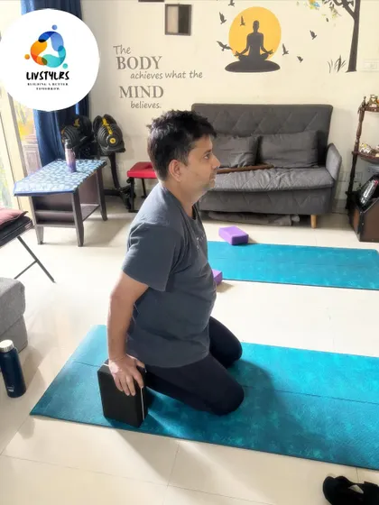 A client uses a yoga block for support while practicing Virasana (Hero Pose). This modification helps to sit comfortably in the pose while gently stretching the thighs and ankles.