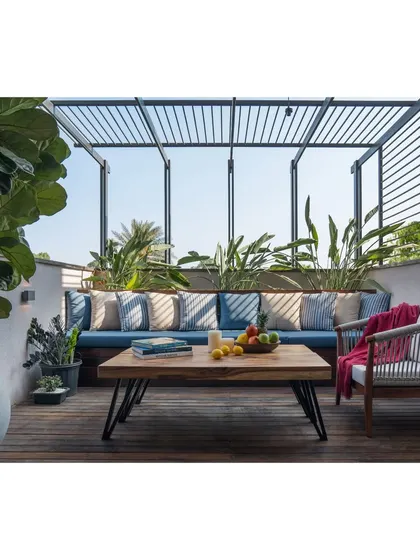 We designed this terrace as a cozy outdoor living room, complete with a built-in sofa, comfortable seating, and plenty of greenery.