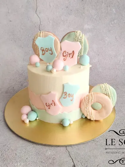 A gender reveal cake with a delicate touch. This 1 kg Chocolate Truffle cake is decorated in soft pastel pink and blue, with custom cookies and mini doughnuts as part of the design.