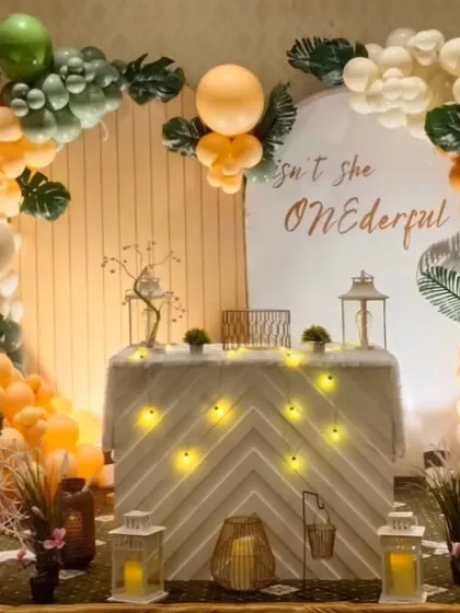 A "Wild One" jungle safari theme with a modern, boho twist. The neutral-toned balloons, pampas grass, and cute giraffe prop create a stylish look for a first birthday.
