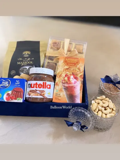 A Ramadan hamper filled with delicious treats. This tray includes Mamool, Nutella, Falooda mix, and jars of cashews, perfect for sharing during Iftar.