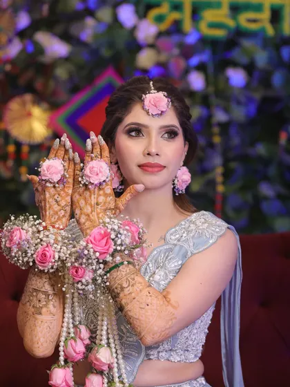Your Mehndi ceremony look should be as vibrant and joyful as the event itself. Here, we created a fresh, elegant look with soft pastel tones on the eyes and glowing skin, perfectly complementing the beautiful floral jewelry.