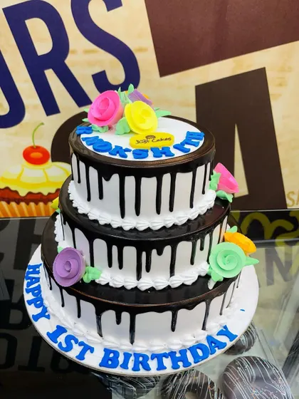 A 3kg three-tiered cake with a classic black chocolate drip and simple floral decorations.