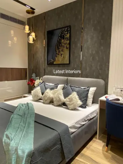 Another angle of the dark-themed bedroom, highlighting the interplay of textures and the warm glow of the pendant lights. The artwork adds a pop of color and personality.
