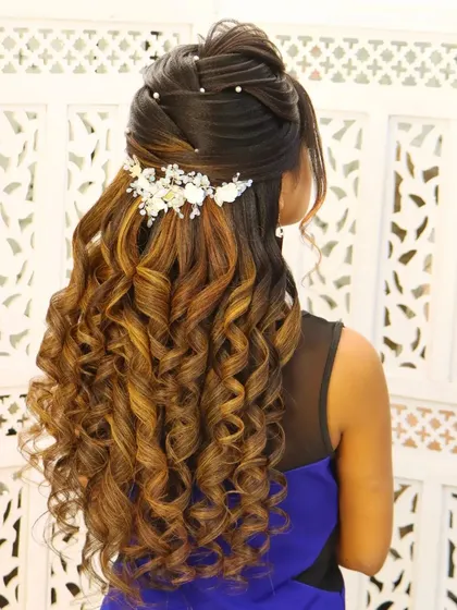 A beautiful engagement look with a half-up style and gorgeous, defined curls. This is a perfect example of a romantic and popular hairstyle for pre-wedding events.