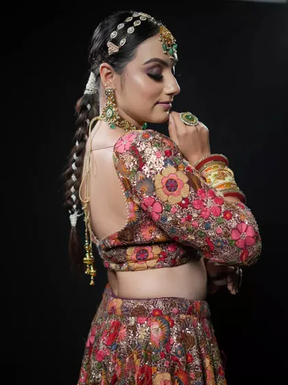 A close-up of the model's face, with the braided ponytail creating a strong and beautiful silhouette. This is a perfect example of a modern bridal look.