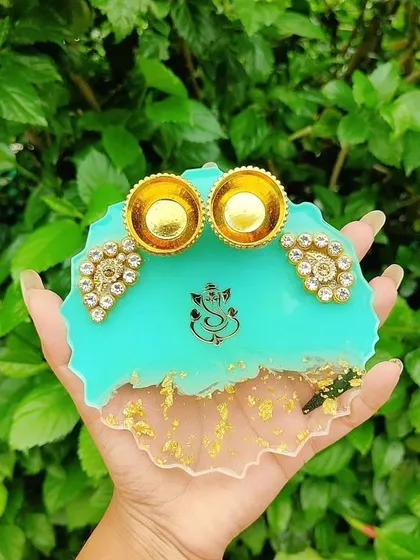 Celebrate festivals with a special touch. This is a custom resin platter I designed for Raksha Bandhan, featuring a vibrant turquoise base, a Ganesha motif, and holders for roli and chawal.
