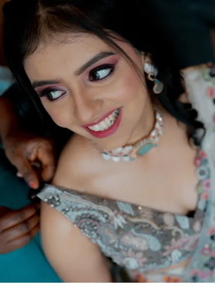 A candid moment during the getting-ready process, as the bride's outfit is adjusted.