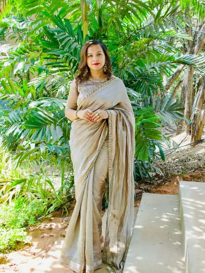 A full-length shot of the client in her sophisticated beige saree.