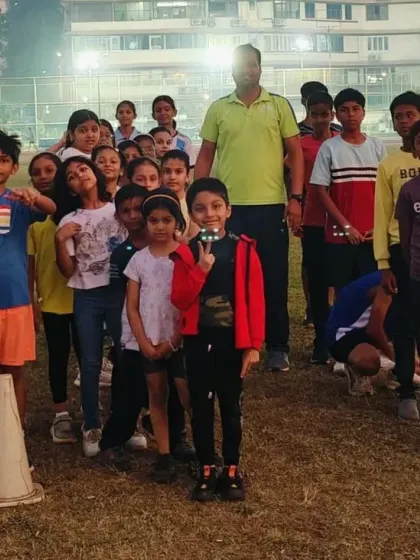 A happy team of young athletes posing with their coaches after a rewarding evening training session. Building a strong sense of community and friendship is a core part of my program.