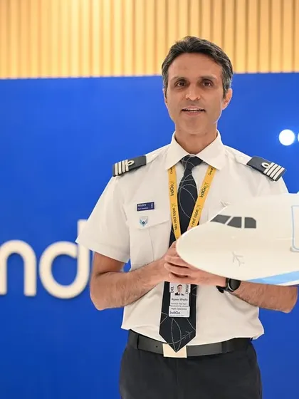A portrait of a pilot holding a model airplane, with the IndiGo logo in the background. This is a great way to create a multi-layered branding image.