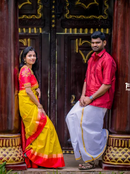 A classic pose against a traditional wooden door. The rich colors of the couple's outfits and the architectural details create a very elegant portrait.