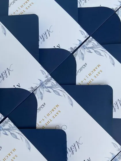 A closer look at the soft blue floral palette used for these "Save The Date" cards. The design combines printed text with spot calligraphy for the couple's names, creating a balanced and beautiful announcement.