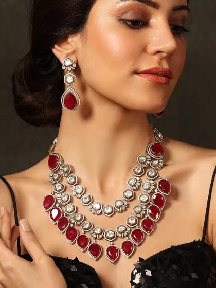 A striking three-layered necklace made with deep red stones and polki diamonds, a bold choice for a dramatic look.