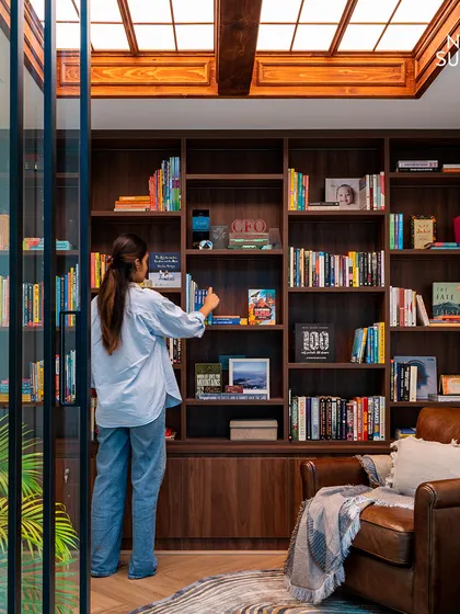 Another view of the home library, showing how the space is both functional for storage and inviting for relaxation. The warm wood and classic furniture create a timeless and scholarly atmosphere.