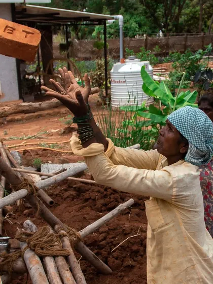 A woman mason skillfully catches a brick on site. This action shot showcases the strength and coordination developed through daily work and training in construction.