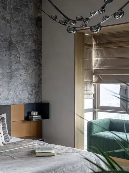 The master bedroom in the Skyward Residence. We used a stunning leather-finished marble slab as a feature behind the bed, contrasting it with warm leather panels for a tactile and luxurious feel.