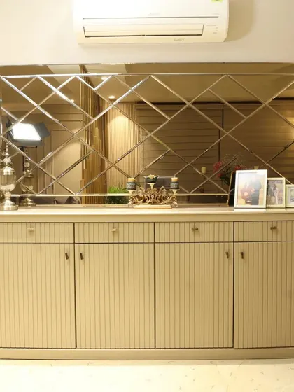 The custom credenza in this dining room features a fluted design and is topped by a large, beveled mirror that expands the visual space.