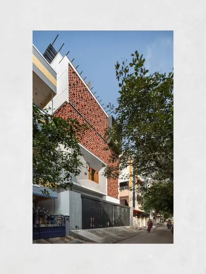 The Kamala Residence in Tirupati, viewed from the street. The terracotta breeze block facade provides a distinctive identity and serves a practical purpose, ensuring ventilation and privacy in a compact urban neighborhood.