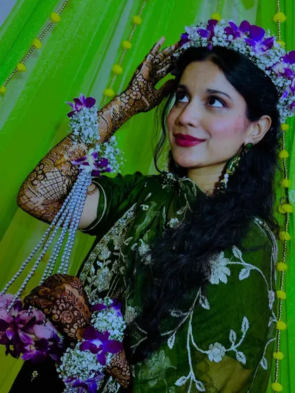 A graceful pose from the bride, showing off her henna and beautiful floral jewelry.