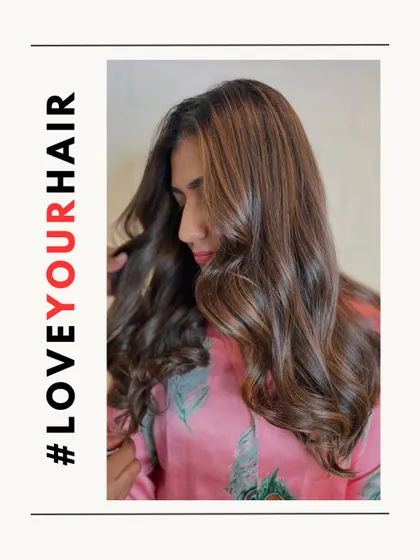 A portrait of the client from our #LoveYourHair series, showing how her new color and style make her feel confident and beautiful.