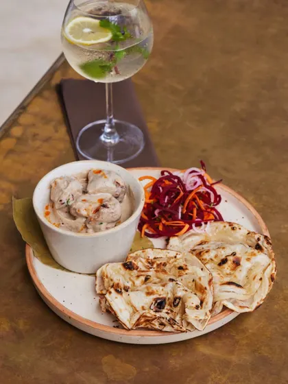 A lighter but equally delicious option. Creamy smoked chicken curry with a delicate rumali roti, paired with a crisp gin and tonic.