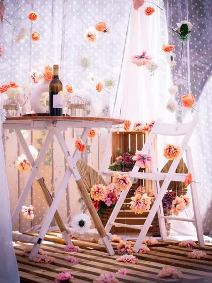 This enchanting canopy setup features delicate flowers that appear to float in mid-air. The rustic wooden furniture and soft color palette create a whimsical and romantic atmosphere for an intimate date.
