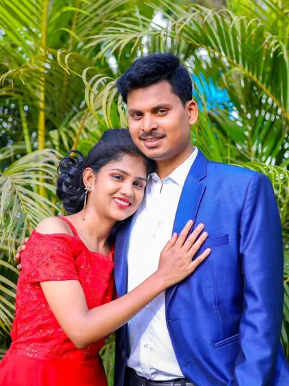A close-up portrait of the couple, capturing their happy expressions and connection. The lush green background adds a touch of nature.