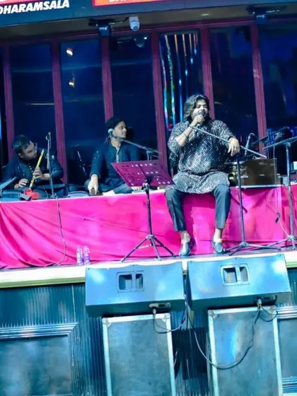A wider view of our stage setup for a club gig, showing the harmonium, flute, and sarangi players in action.