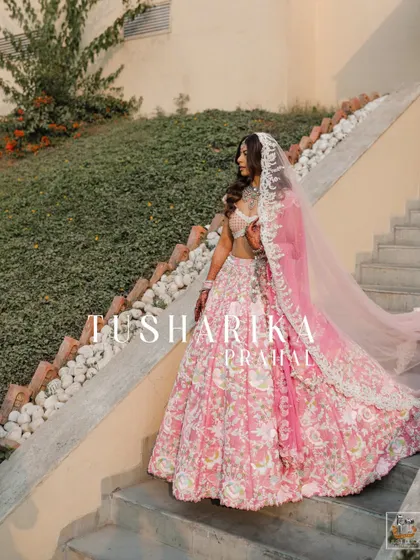 A stunning full-length portrait of the bride in her pink floral lehenga on her wedding day.