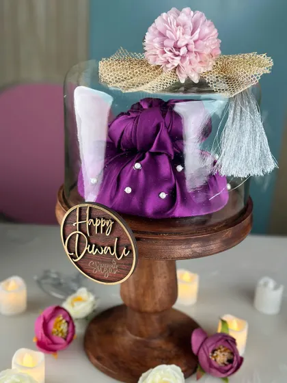 This Diwali hamper is designed as a keepsake. It features a high quality wooden cake stand with a glass dome, containing one of our delicious tea cakes.