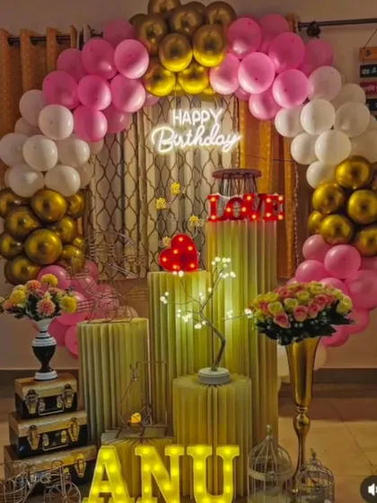 An elegant and romantic birthday decoration perfect for a surprise at home. The pink, white, and gold balloon arch, combined with light-up letters and props, creates a warm and celebratory feel.