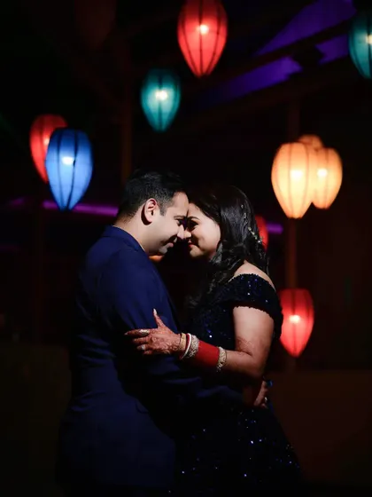 A romantic portrait of the couple surrounded by colorful lanterns. The soft lighting and their close embrace create an intimate and magical atmosphere, perfect for a post-wedding shoot.