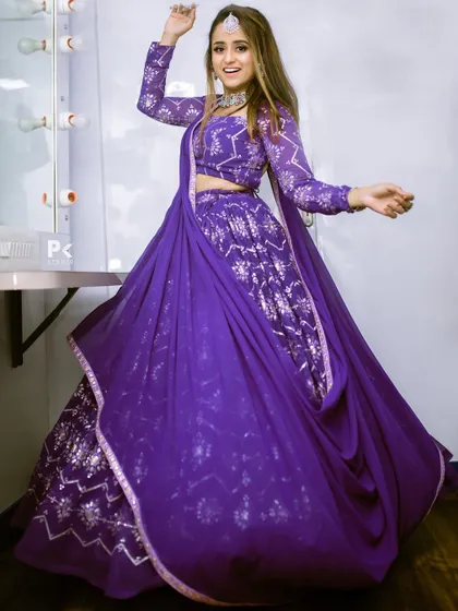 The model twirling in the purple foil-print lehenga, showing the beautiful movement and flare of the skirt.