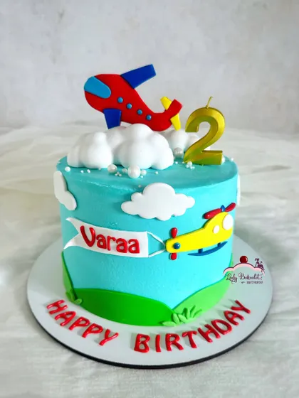 Up, up, and away! An airplane and helicopter-themed cake, perfect for a little aviator. The fluffy buttercream clouds make it feel like it's flying in the sky.