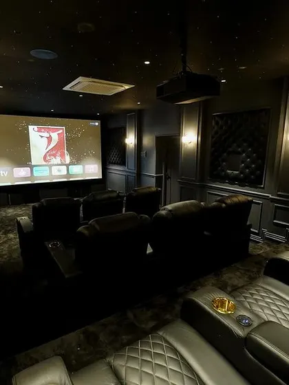 This wide shot captures the entire theater, from the comfortable seating in the foreground to the large, vibrant screen in the back.