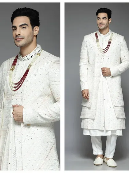 A white layered sherwani with a contrasting red and pearl necklace. This pre-loved piece is a perfect blend of tradition and modern accessorizing.