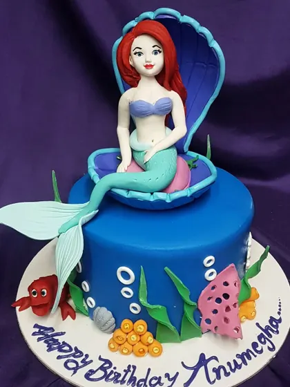 This classic mermaid cake features Ariel sitting in a beautiful seashell. The vibrant blue and intricate details bring the underwater Disney magic to life.