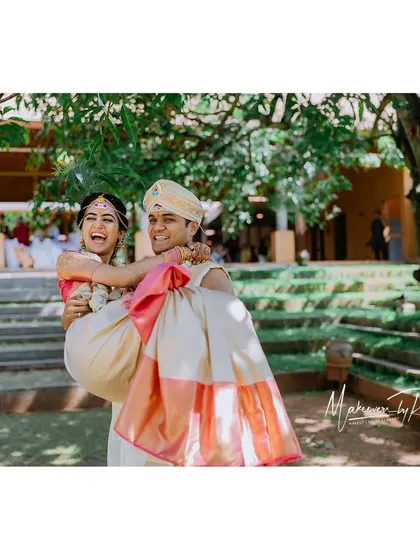 The groom playfully carrying his bride, a moment of pure happiness.