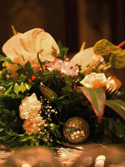 Another angle of the floral centerpiece, highlighting the unique shapes of the anthurium flowers and the soft glow of the surrounding lights.