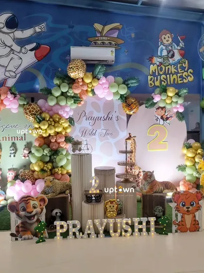 A "Wild Two" jungle theme with cute tiger cubs and a mix of pink and green balloons.