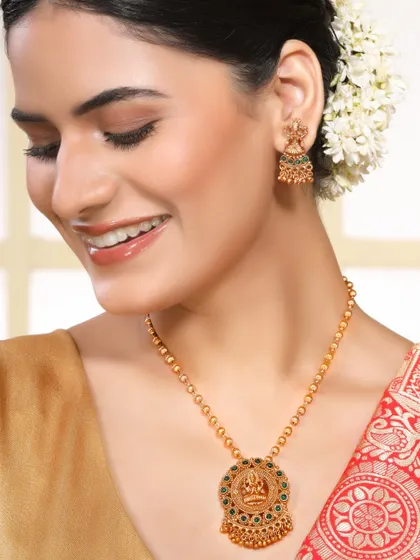 A smiling model displays a beautiful temple jewellery necklace with a goddess motif, connecting with customers on a cultural level.