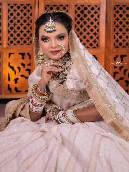 A classic portrait pose, with the bride's hand gently touching her chin. Her direct gaze and confident expression make this a very strong and captivating image.