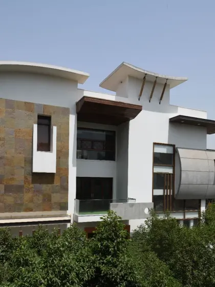 The façade of the Ashraya Residence is a composition of stepped gardens and varied materials. A cantilevered box on the first floor houses a secluded study, while the use of slate stone and teak wood brings warmth and authenticity.