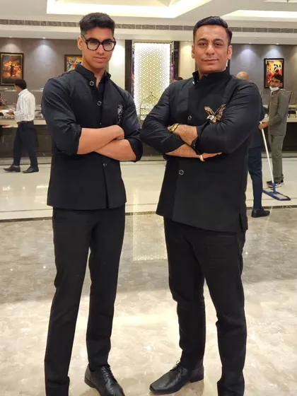Like father, like son. Dressed in matching custom-tailored black Jodhpuri jackets, this is a moment of pride for our family and our craft.