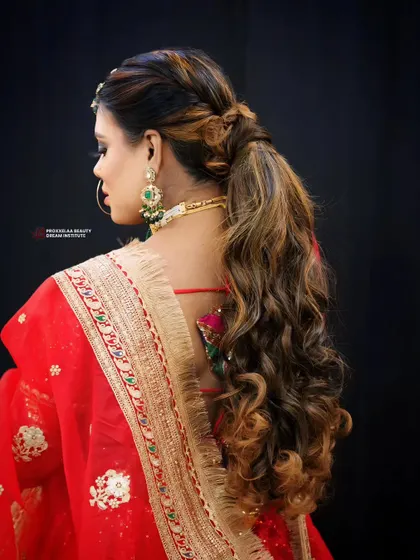 Embracing tradition with a modern twist. This hairstyle combines soft curls with a stylish ponytail, perfect for complementing a traditional Indian outfit.