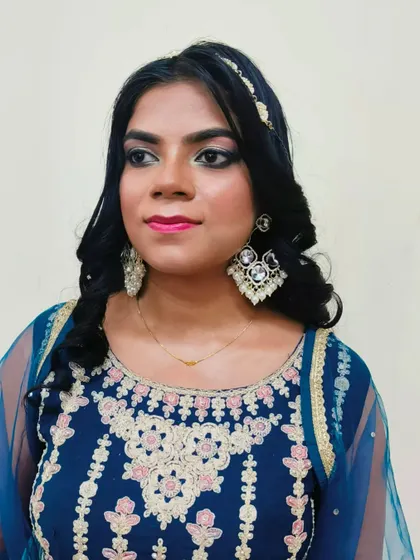 A simple and elegant engagement look created by a student. This style features soft smokey eyes, a bright pink lip, and gentle curls, perfect for pre-wedding functions.