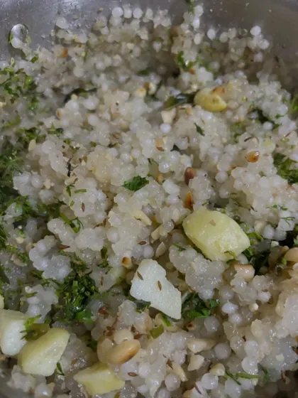 A bowl of Sabudana Khichdi, a light and popular dish often made for fasting. It's prepared with tapioca pearls, peanuts, potatoes, and fresh herbs.