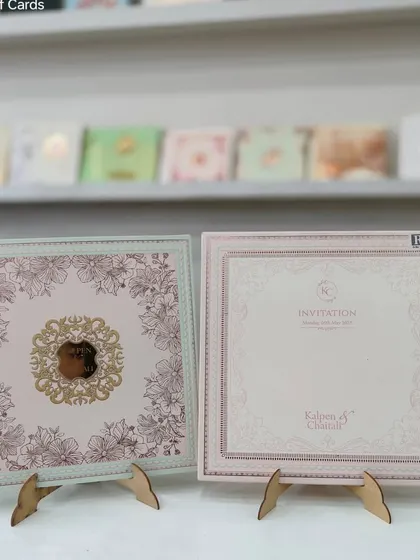 A square pastel invitation with a floral design and a gold foil monogram. The soft pink and mint green colors are perfect for a spring wedding.